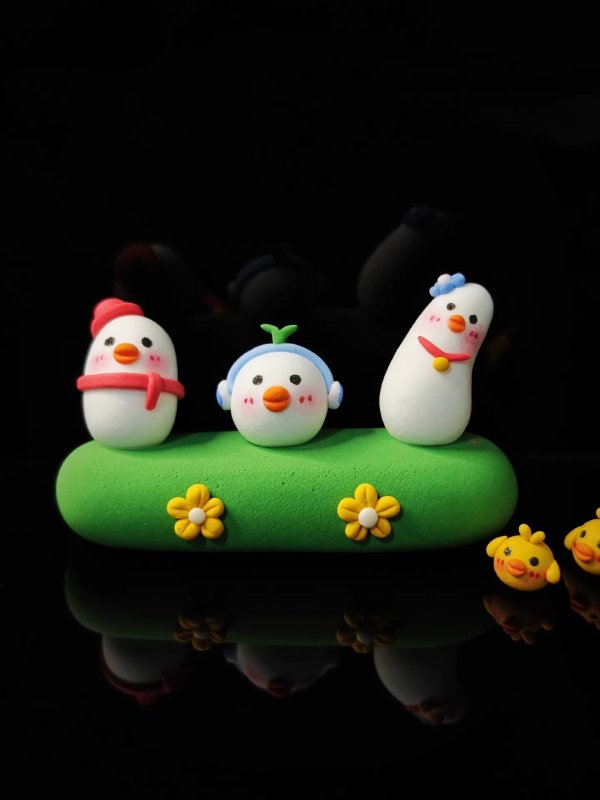 Three Charming Clay Ducks on a Lush Grassland