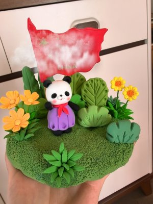 Playful Clay Panda with Flag and Flowers